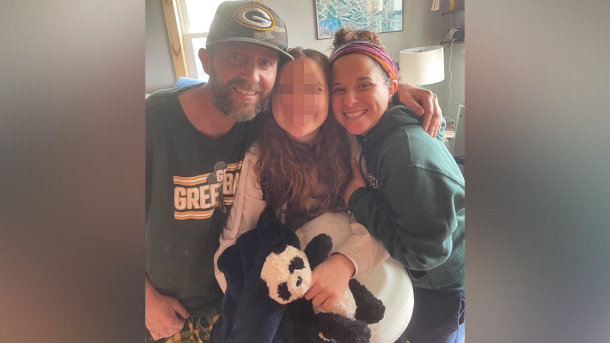 Cassie Wilusz, her late husband Dave Wilusz, and their 14-year-old daughter. Michael Arnold is accused of flying his small plane over her home as her husband was dying of colon cancer.