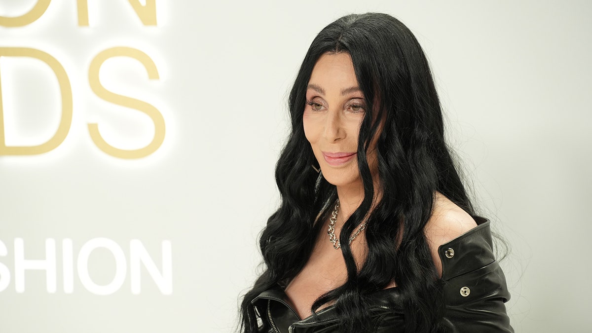Cher with black hair posing on the red carpet