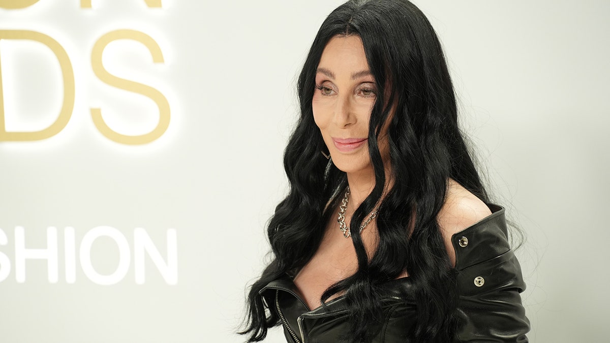 Cher with black hair posing on the red carpet