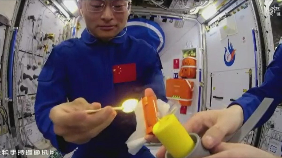 Chinese astronauts lighting fire to a candle in space