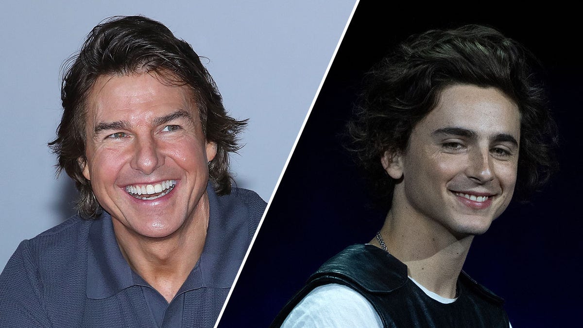 Tom Cruise in a blue collar shirt laughs and looks to his left split Timothée Chalamet in a white shirt and black vest smiles on stage and looks to his right