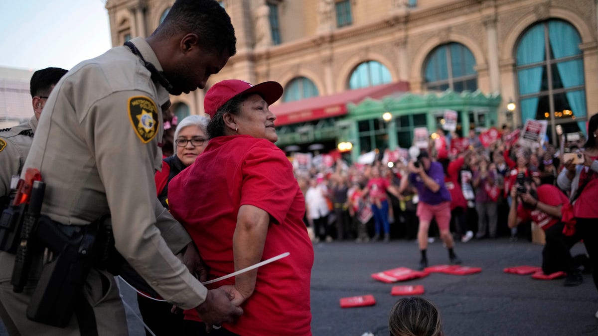 A Las Vegas police officer arrests a Culinary Workers Union member in Las Vegas