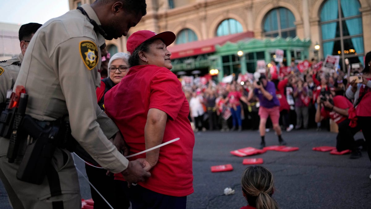 A Las Vegas police officer arrests a Culinary Workers Union member in Las Vegas