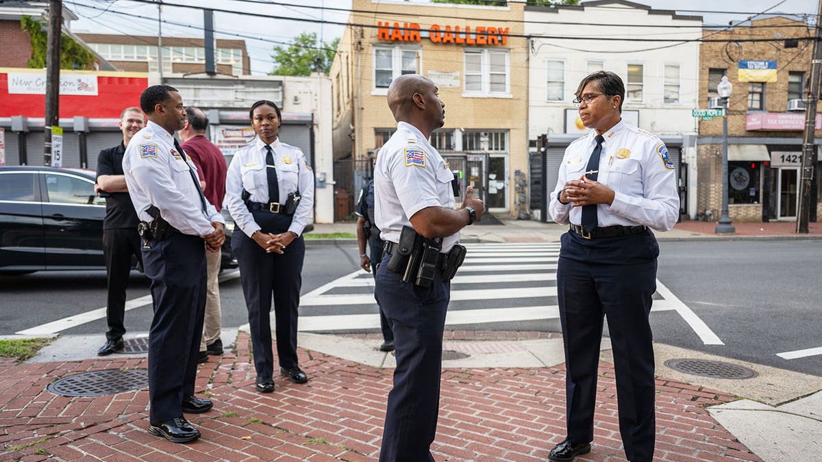 Pamela Smith, right, acting DC police chief, talks to police officer
