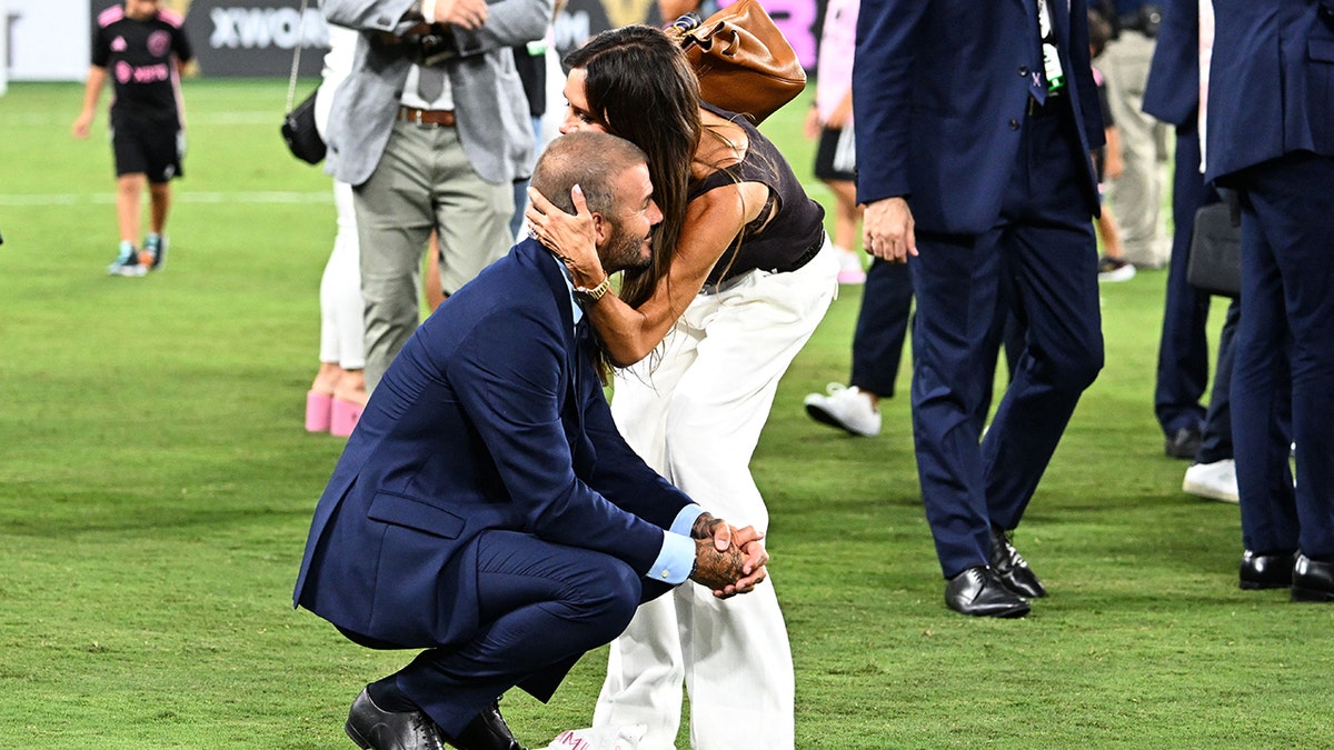 David Beckham and Victoria Beckham on a soccer field