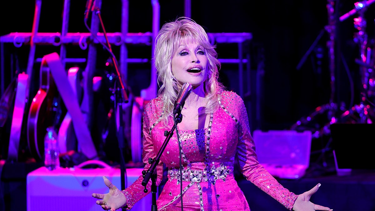 Dolly Parton singing into a microphone on stage