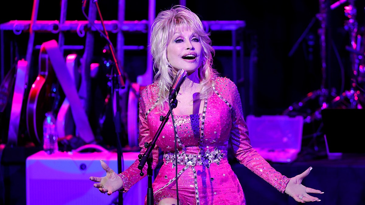 Dolly Parton singing into a microphone on stage