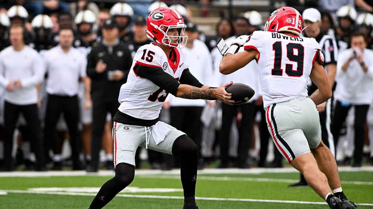 Carson Beck hands the ball to Brock Bowers