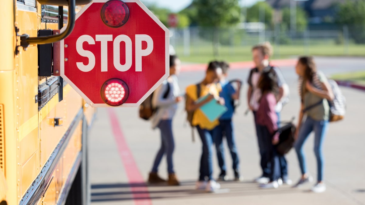 School children in lot with bus