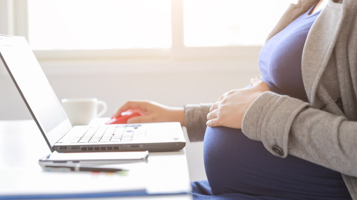 pregnant woman is working on computer laptop and mobile phone, business