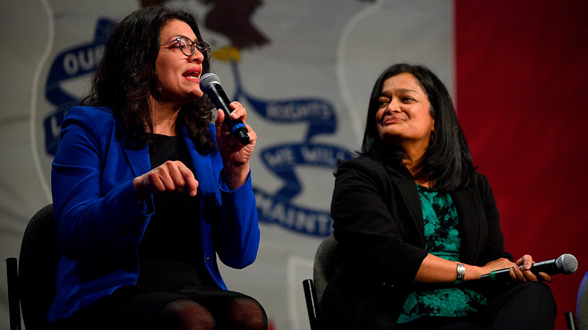 Jayapal smiles ar Tlaib on stage of Bernie Sanders event