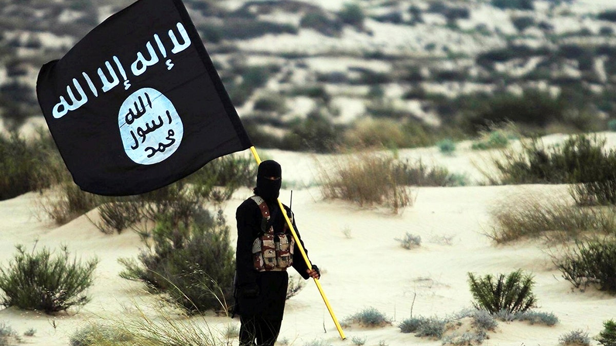 Soldado do ISIS segurando uma bandeira