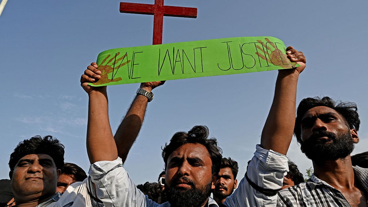 man holding sign saying "we want justice." 