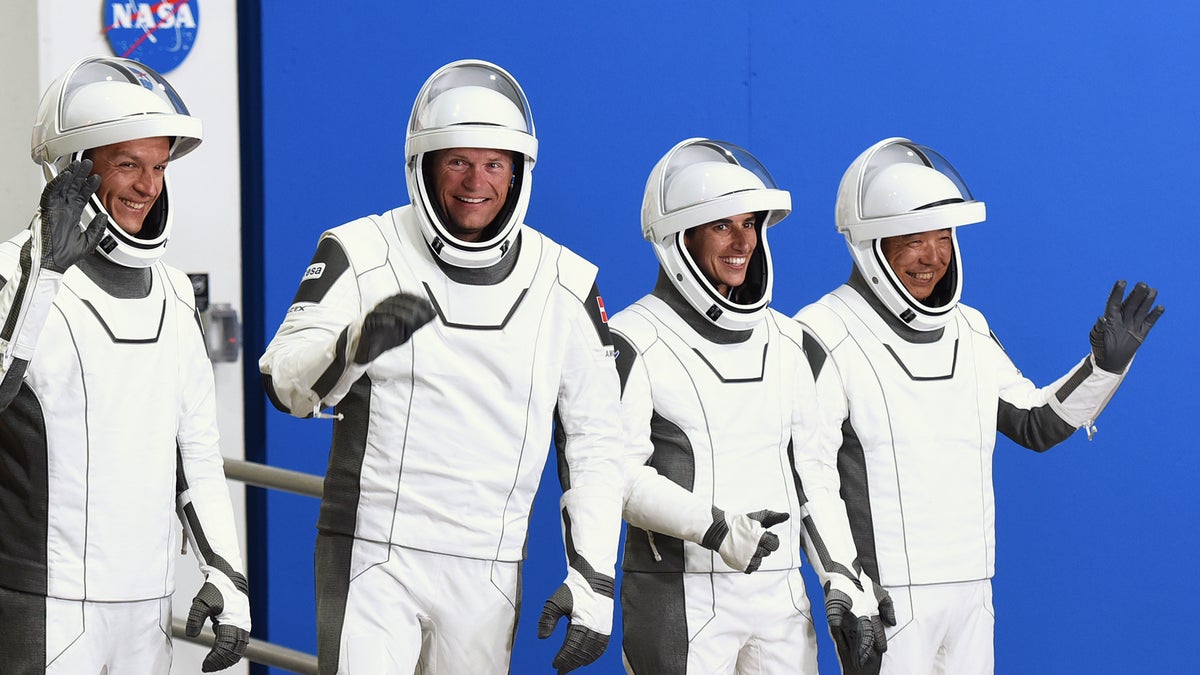 Crew-7 members wave to the cameras while wearing their space suits before launch