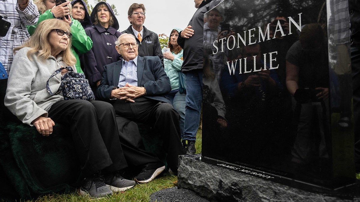 People at Stoneman Willie's burial; tombstone reading 'stoneman willie' and 'james murphy'