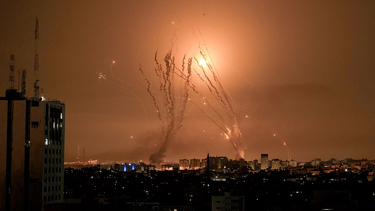 Palestinian militants in the Gaza Strip fire a salvo of rockets as an Israeli Iron Dome missile attempts to intercept them over the city of Netivot, Israel, on Oct. 8, 2023.