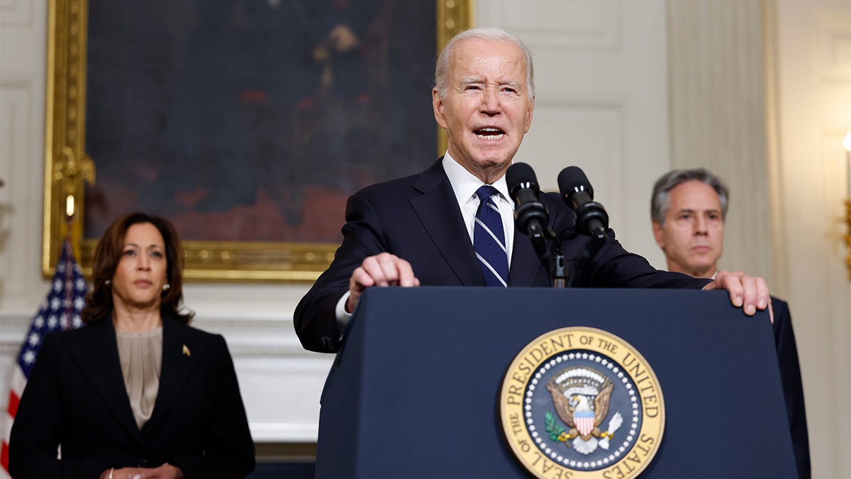 Biden at White House lectern, VP Harris (left) and Antony Blinken (right) behind him