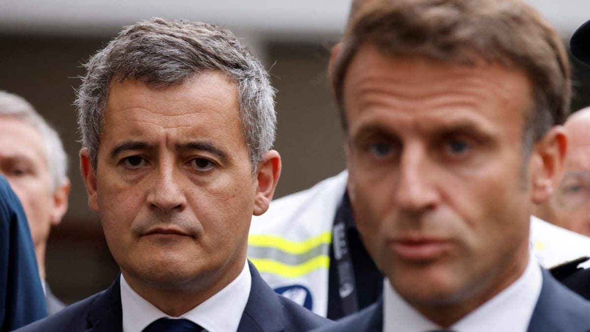 French Interior Minister Gerald Darmanin, left, stands next to French President Emmanuel Macron