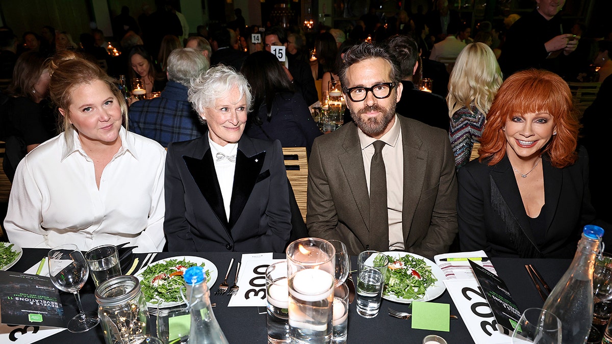 Amy Schumer, Glenn Close, Ryan Reynolds, and Reba McEntire sit at a table together