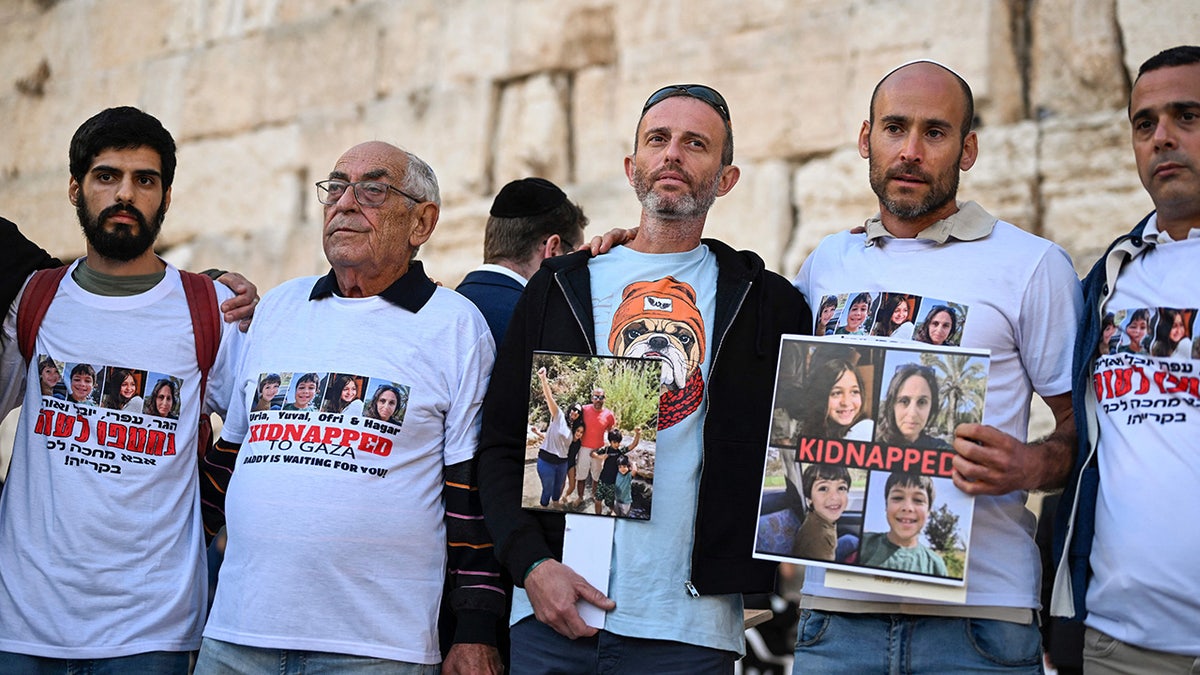 Protesters hold photos of hostages taken by Hamas