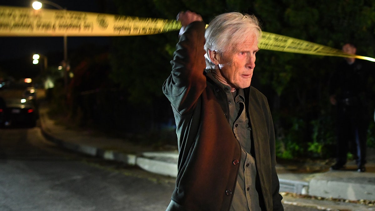 A photo of Keith Morrison crossing police tape near Matthew Perry's home