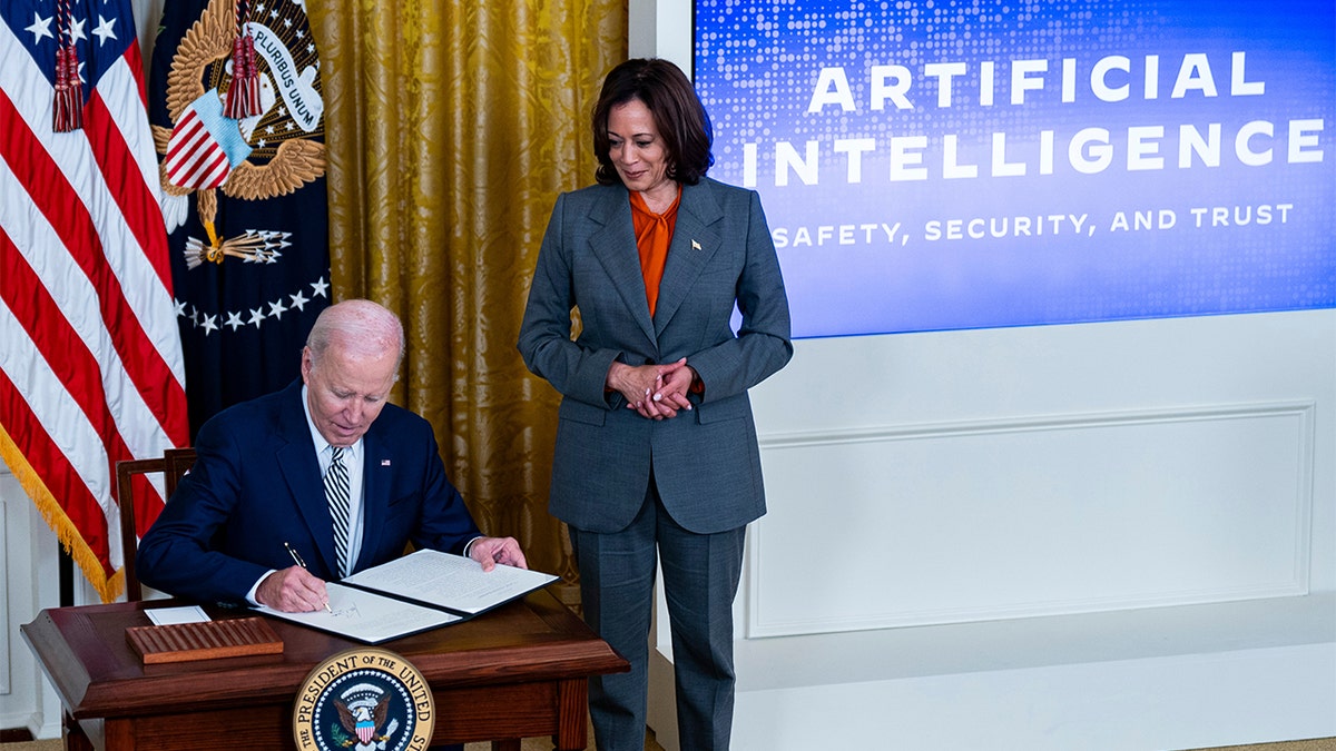 Vice President Kamala Harris, right, with seated President Biden signing executive order