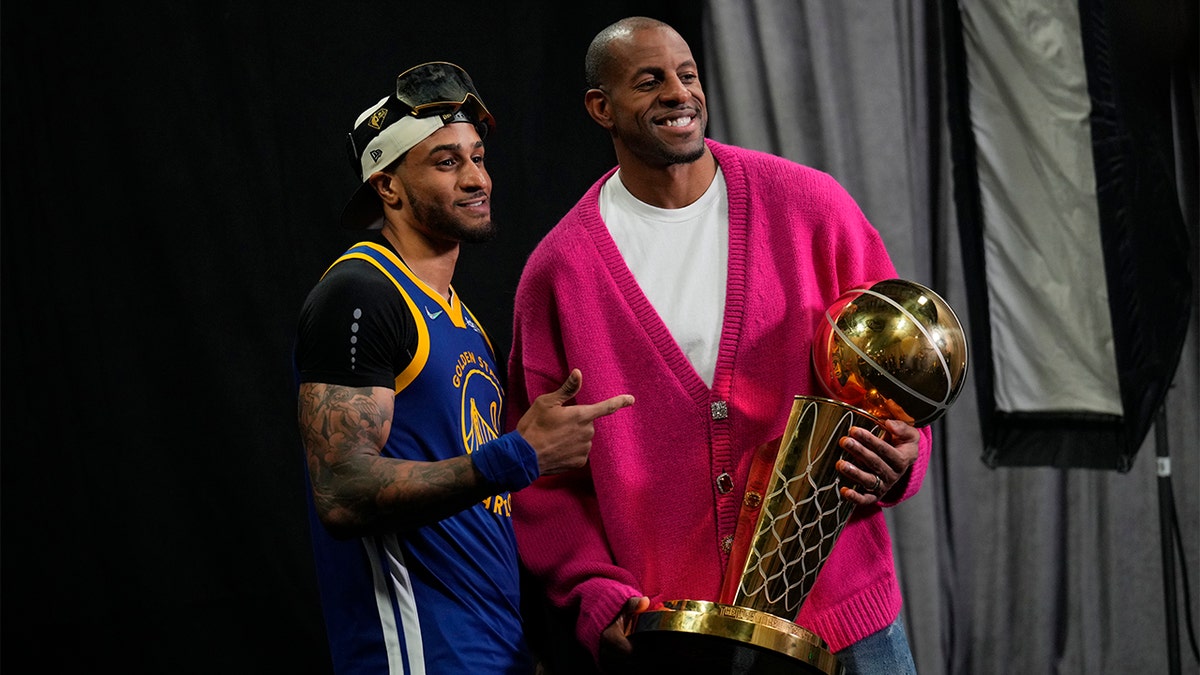 Gary Payton II and Andre Iguodala with the championship trophy