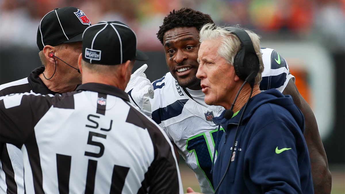 DK Metcalf and Pete Carroll speak with officials