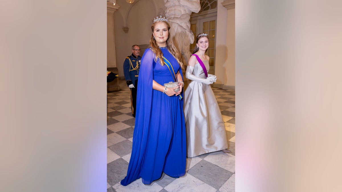 Two princesses in a royal blue and silver gown with tiaras