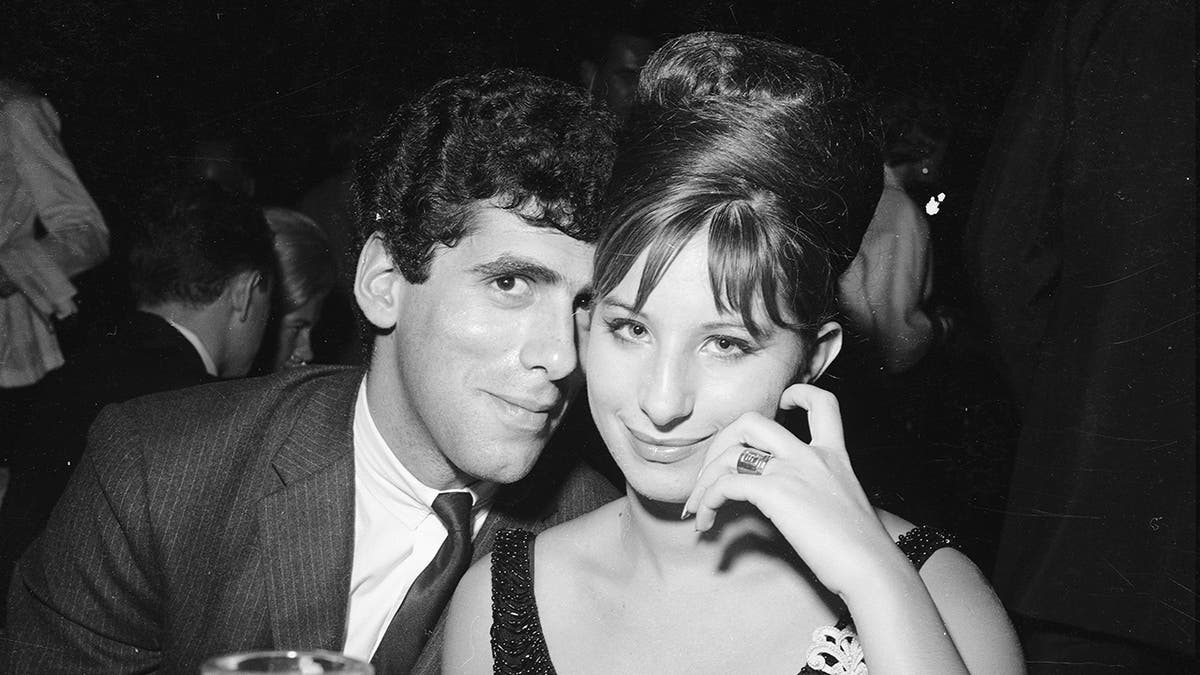 Elliott Gould leaning against Barbra Streisand as they both smile