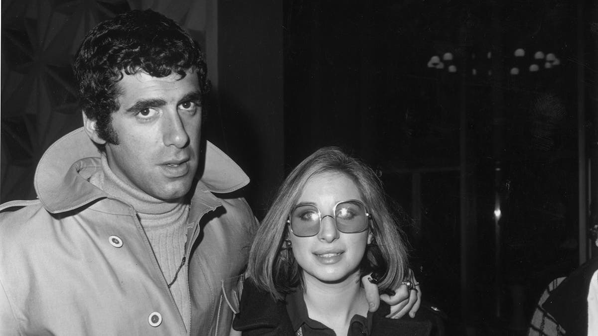 Elliott Gould and Barbra Streisand looking serious directly at the camera