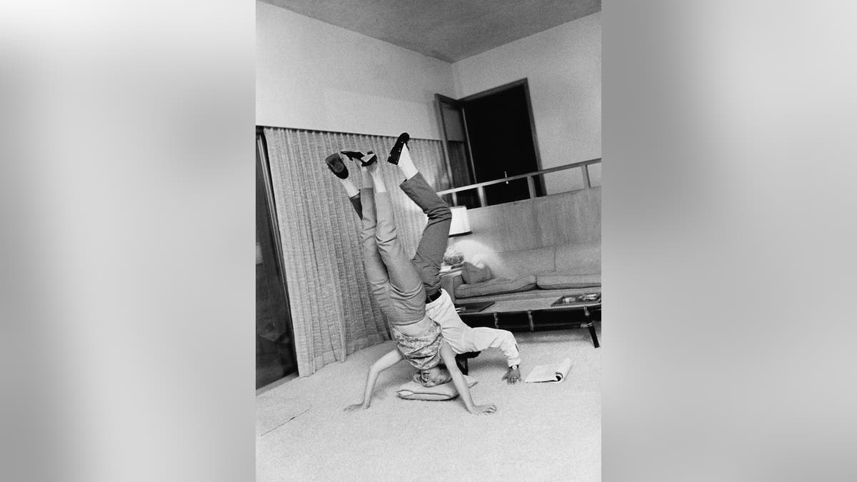 Paul Newman and Joanne Woodward doing a handstand
