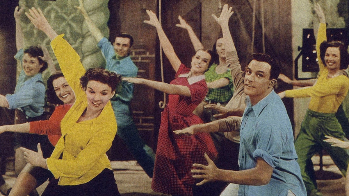Actors including Judy Garland and Gene Kelly dancing wearing colorful shirts