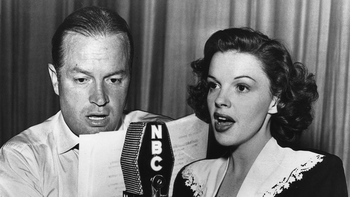 Judy Garland singing in front of an NBC mic as Bob Hope reads from a paper