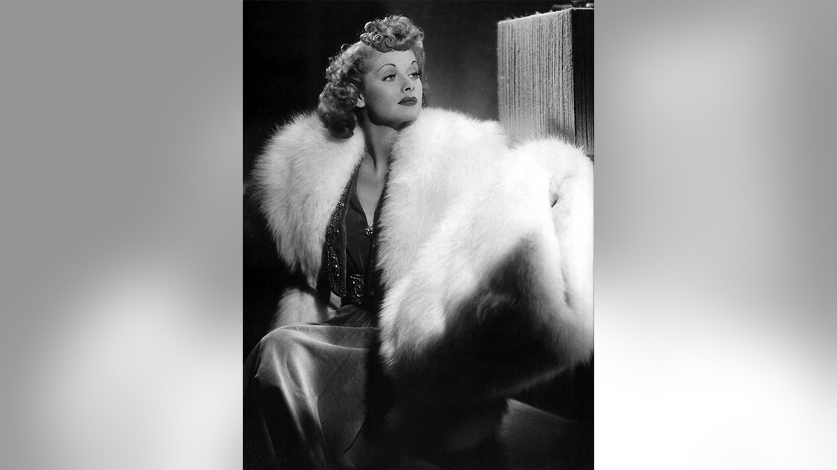 Lucille Ball wearing a white fur coat and sparkling dress