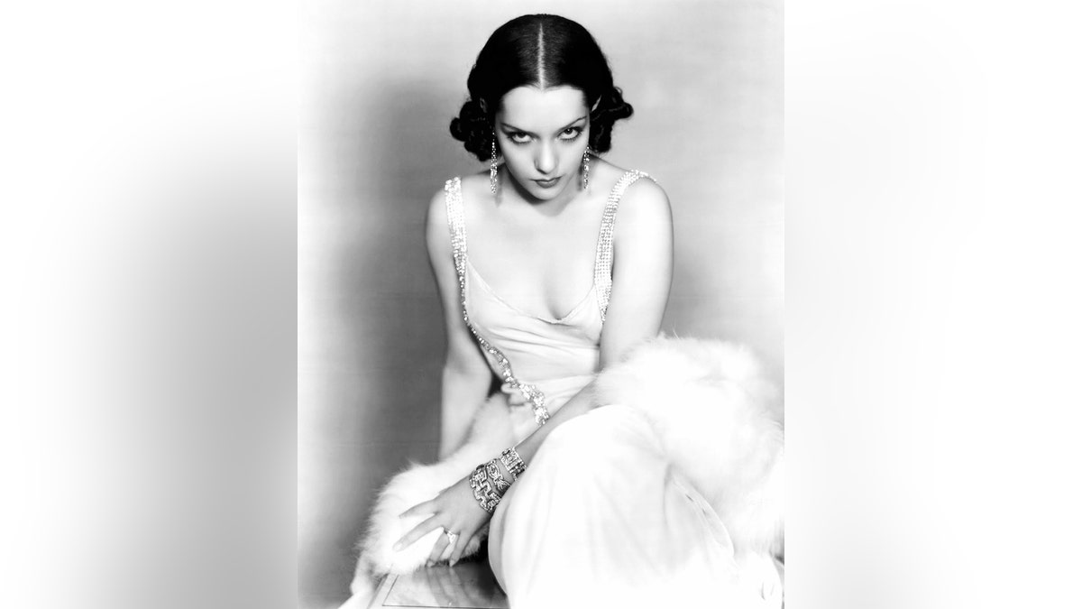 Lupe Velez wearing a white evening gown with jewels