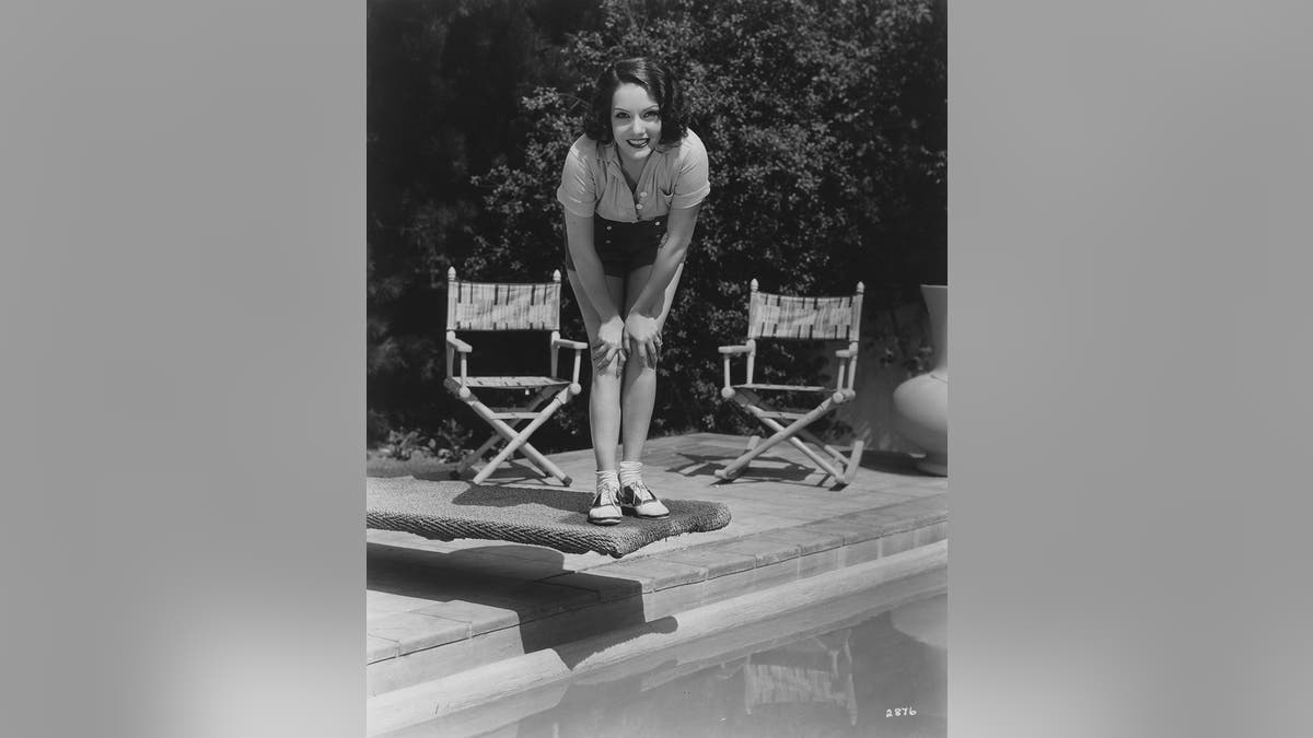 Lupe Velez leaning down next to two chairs