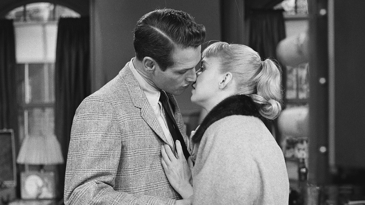 Paul Newman si china per ricevere un bacio da Joanne Woodward