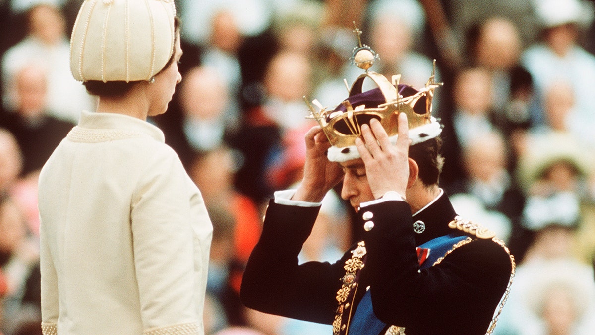 Prince Charles being crowned as he kneels in front of Queen Elizabeth
