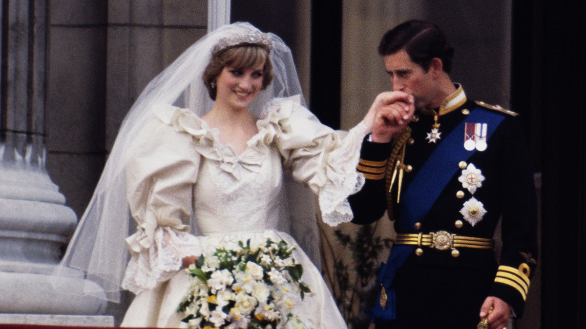 Prince Charles kissing Princess Diana's hand on their wedding day