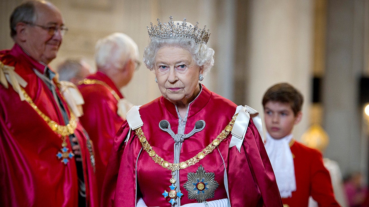 Queen Elizabeth II wearing a red gown and a crown