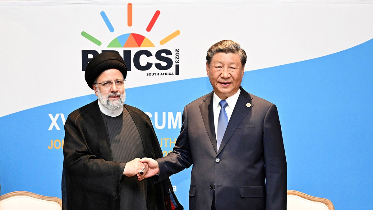 Iranian President Ebrahim Raisi shakes hands with Chinese President Xi Jinping