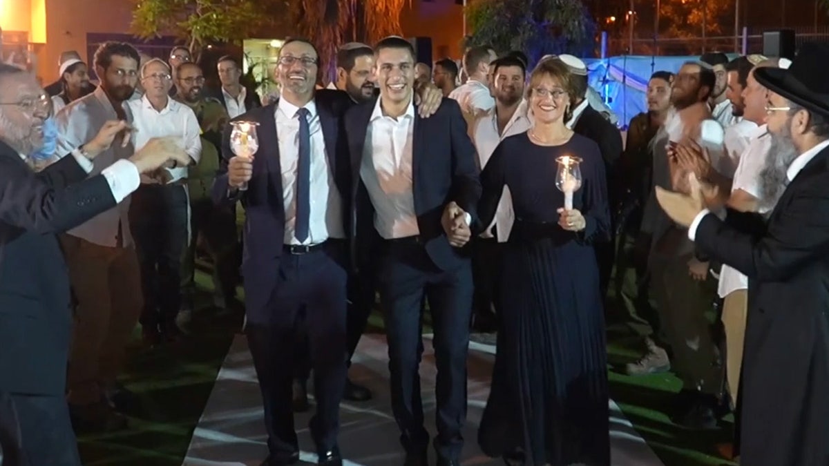 Groom and his parents at a Jewish wedding.