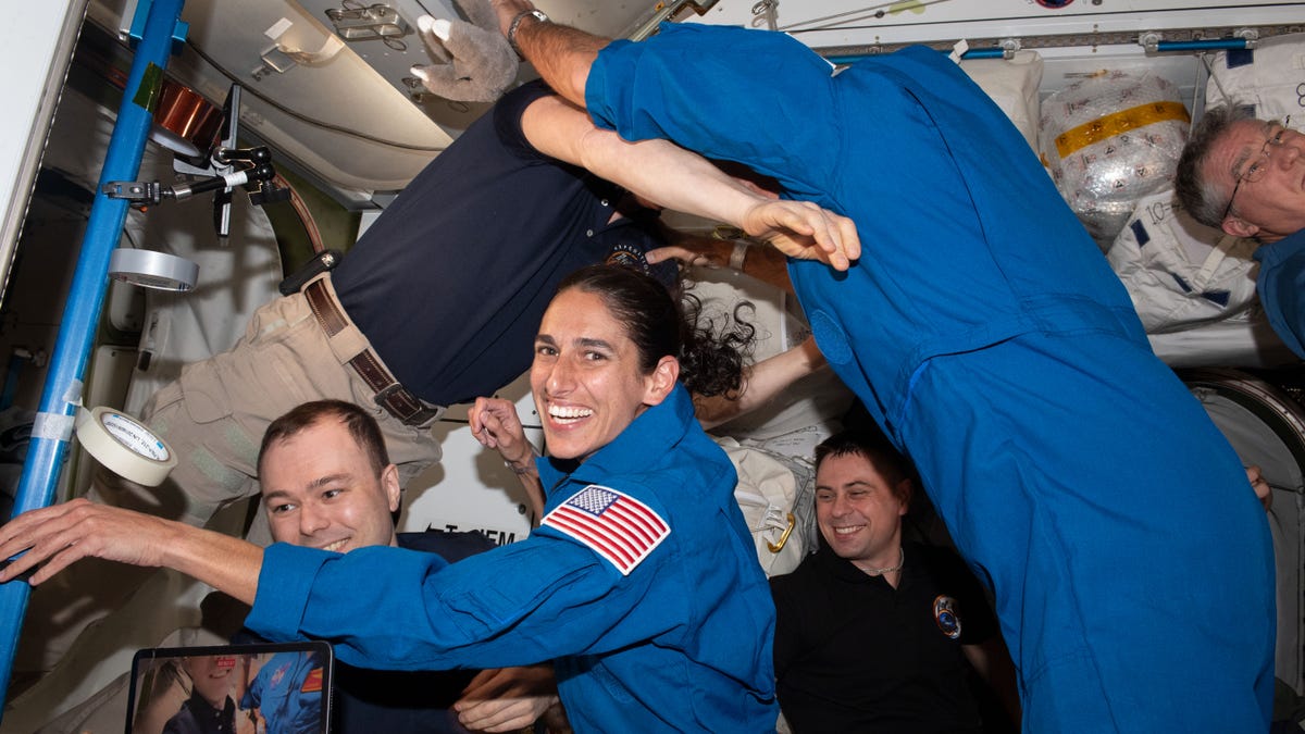 NASA astronaut Jasmin Moghbel surrounded with floating crewmates aboard the ISS