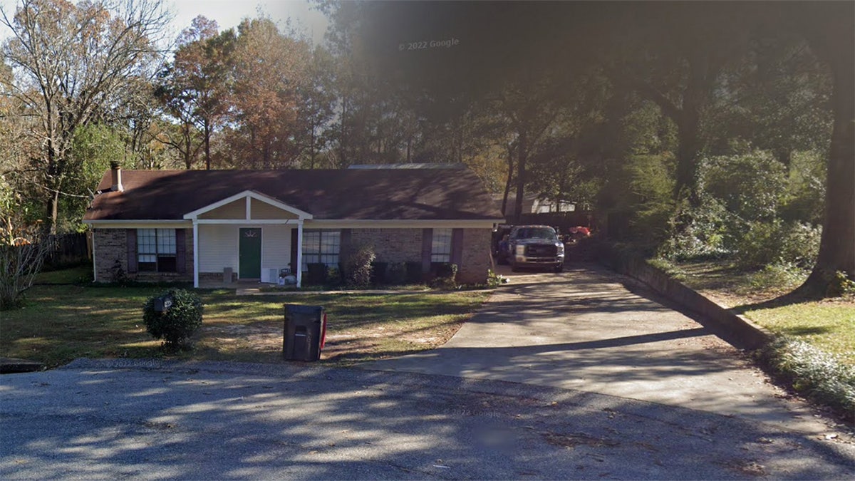 A single story home with a long driveway.