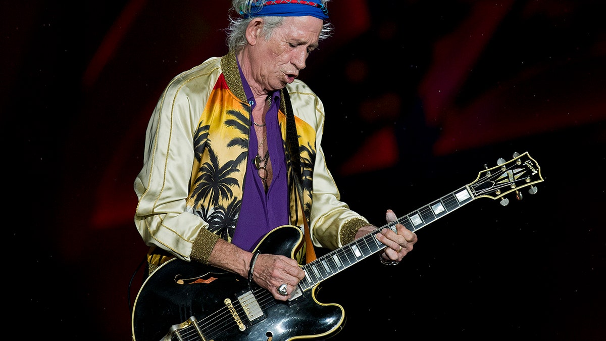 Keith Richards playing guitar in profile