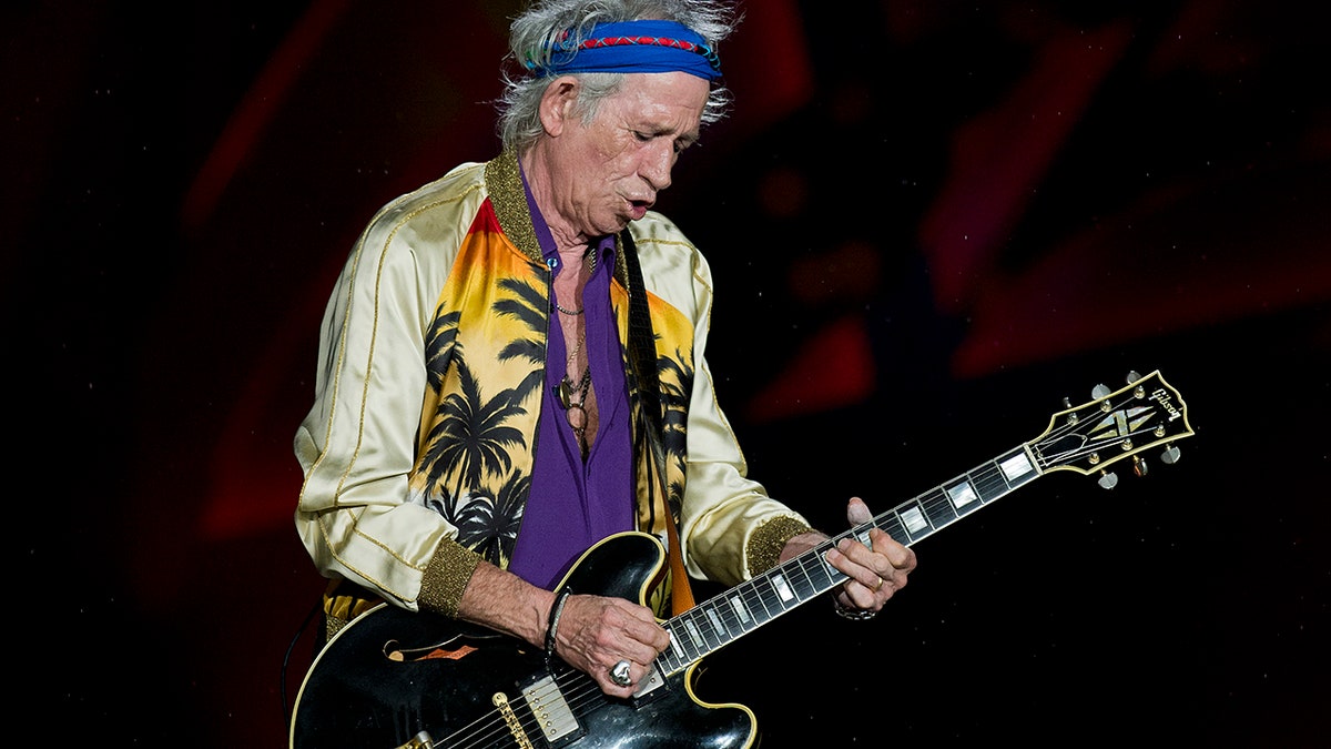 Keith Richards playing guitar in profile