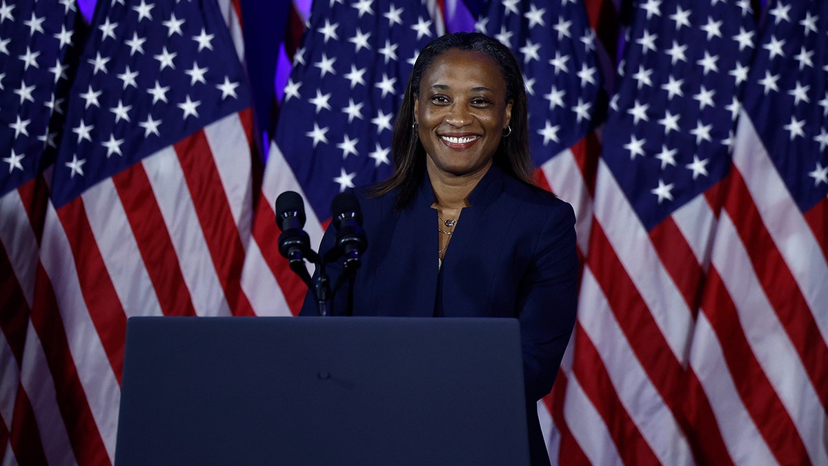 Laphonza Butler in front of American flags
