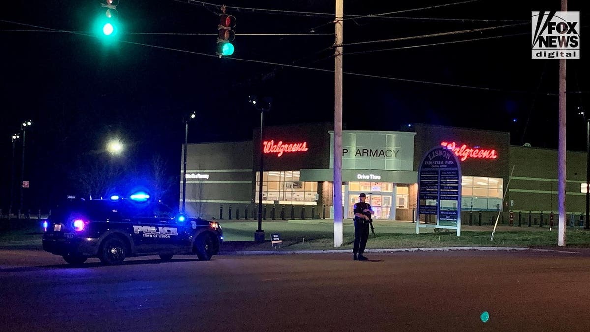 Police stand guard where the Lewiston shooter, Richard Card was found dead tonight