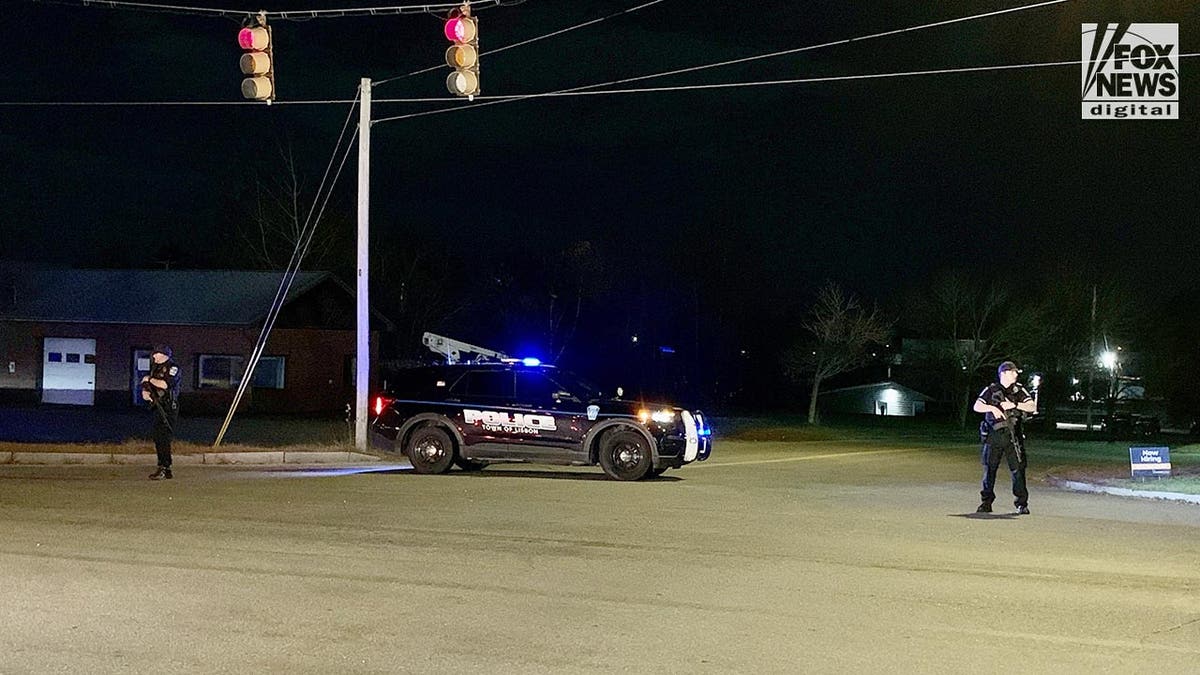 Police stand guard where the Lewiston shooter, Richard Card was found dead tonight